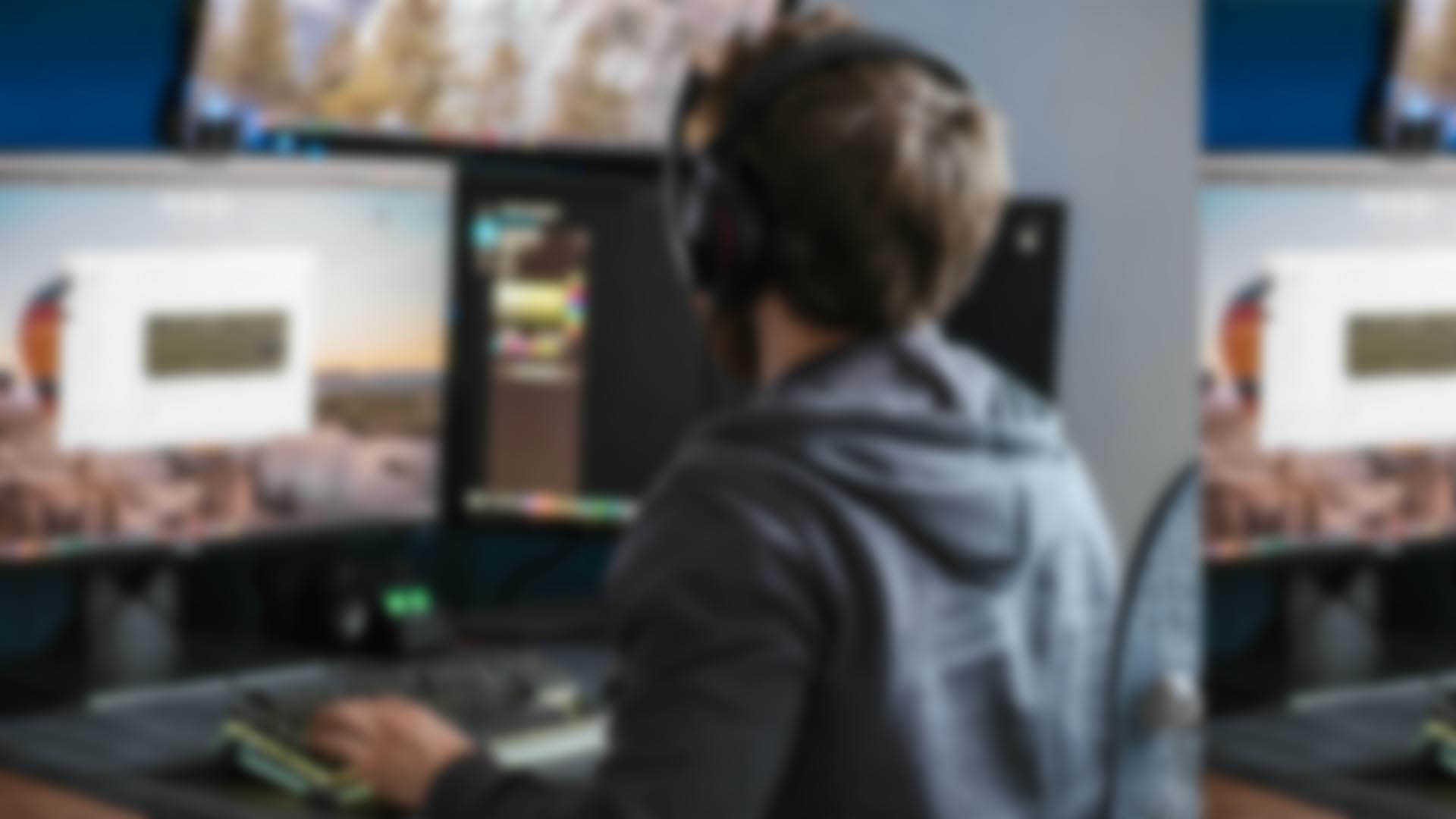 Digital artist working on multiple monitors with creative design software.